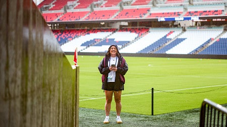 Vanesa Montalvo stands on the field at a large soccer stadium