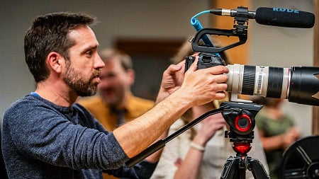 Zach Putnam works with a large video camera