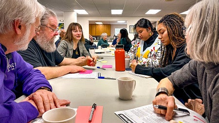 students and community members sit around a conference table