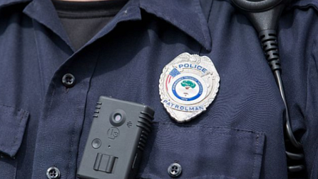 A body camera is attached to the front of a police officer's uniform, just underneath their badge (photo by Ryan Johnson). 