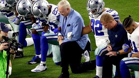 The Dallas Cowboys, led by owner Jerry Jones, center, take a knee prior to the national anthem before an NFL football game against the Arizona Cardinals in Glendale, Arizona.