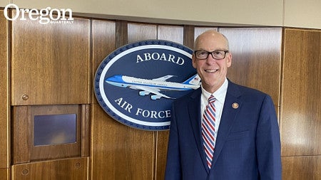 Greg Walden, a former U.S. Representative, smiles at the camera while standing in front of a U.S. Air Force sign. 