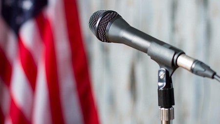 Microphone in front of the American flag.