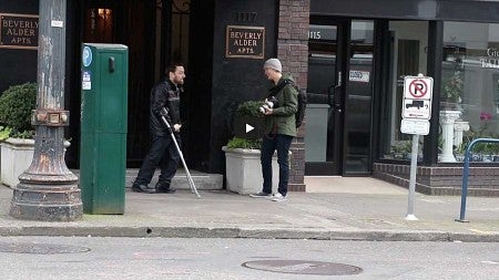 Filming a Portland resident walking down the street using a crutch