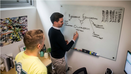 Center for Science Communication Research program assistant Ian Winbrock (right) explains the center's priorities to a student.