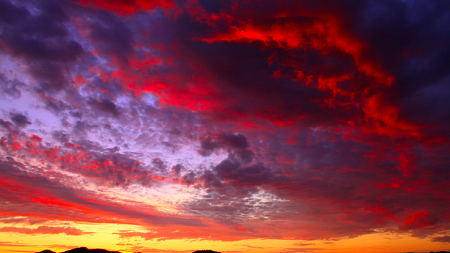 Setting sun and colorful clouds over a desert.