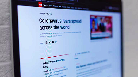 A computer screen with a CNN article pulled up about the COVID-19 pandemic.