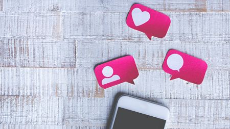 A phone on a white background below pink social media icons.