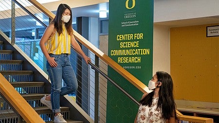 Two students stand in front of a Center for Science Communication Research sign. 