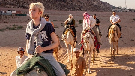 University of Oregon students riding camels while on a study abroad trip in the desert