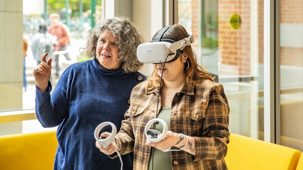 Donna Davis works with a student using VR gear