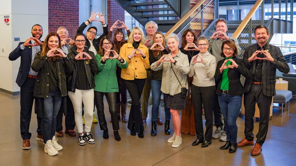 group photo of the SOJC journalism advancement council throwing their o's