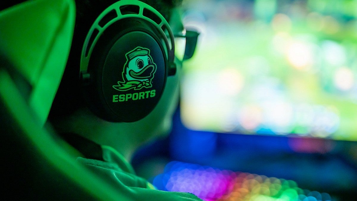Person playing esports wearing headphones with a duck logo. Person playing esports wearing headphones with a duck logo.