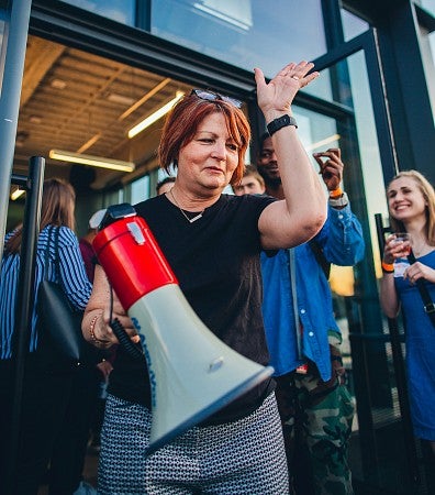 Deb Morrison holds a bullhorn and gestures with her arm up on a trip to New York City