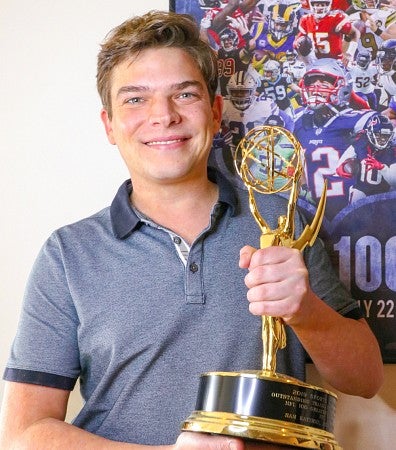 portrait of Sam Katzman holding an Emmy award