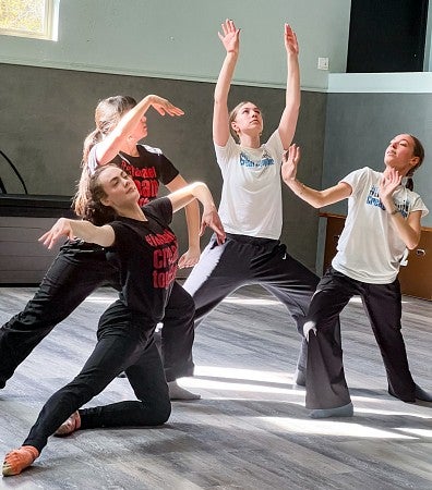 a group of four dancers hold poses in a tableau
