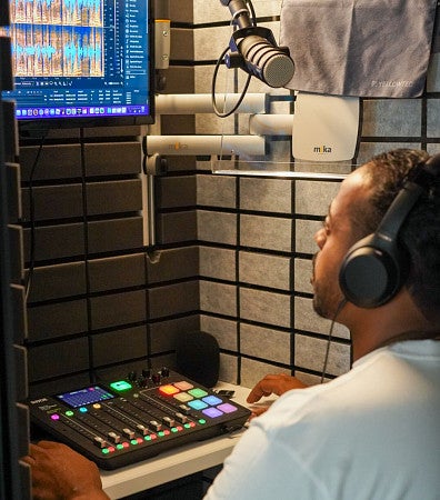 Berto Jolliffe edits audio on a computer screen in a recording studio