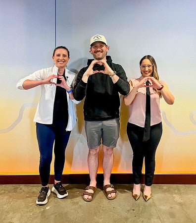 three people holding their hands in the shape of Os