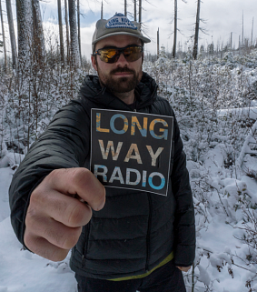 Jack Fisher holding Long Way Radio podcast sticker