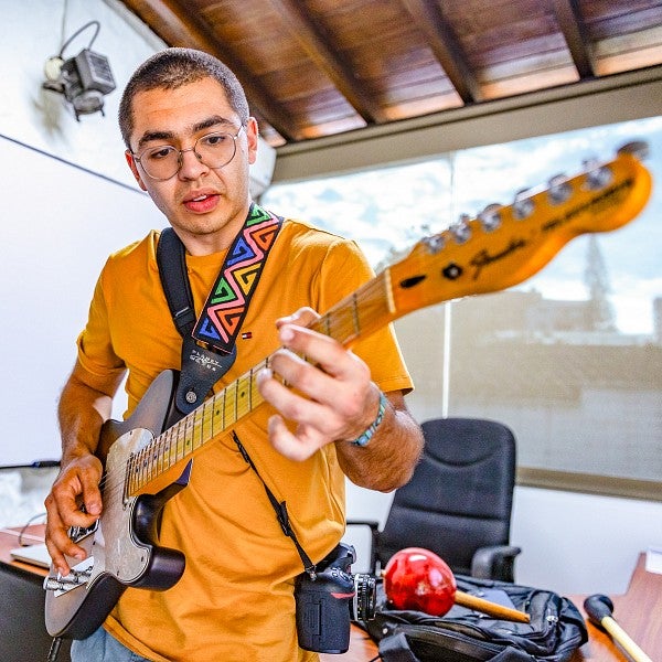 Josiah Pensado Alvarenga plays the guitar