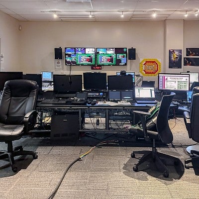 several computer stations and screens in a control room