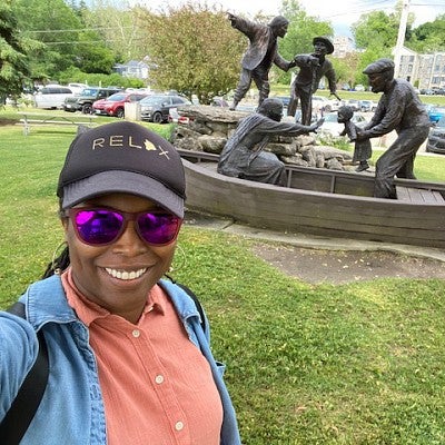 Jakki Bailey takes a selfie in front of a monument