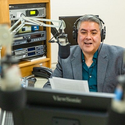 Brian Bull sits in front of a microphone at the KLCC recording studio