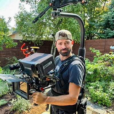 Kyle LaMontagne poses while wearing a large stabilized camera rig
