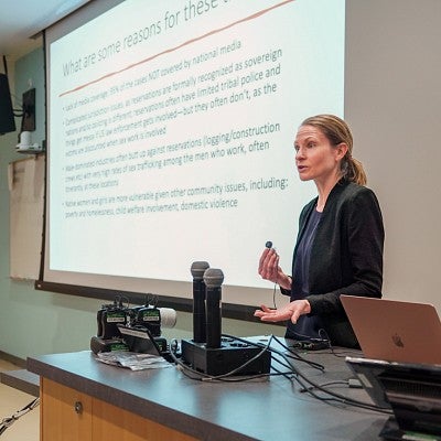 Whitney Phillips presents in front of a classroom digital screen