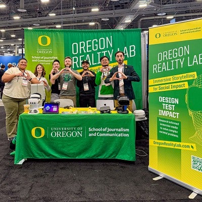 seven people throw their Os at a vibrant green and yellow branded exhibitor booth