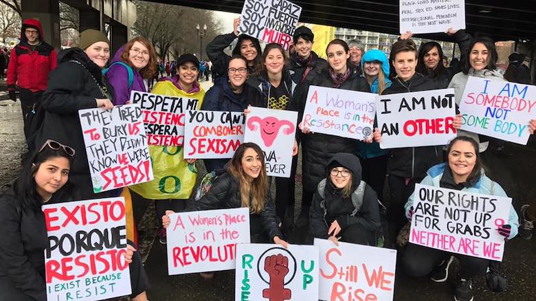 Kiva Hanson and fellow activists speak out in support of women’s rights. Group photo of students holding signs in support of women's rights.
