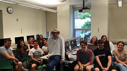 Professor Laufer and his Advanced Reporting students smile for a picture together in a classroom.