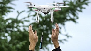 A drone lifting off from a person's hands