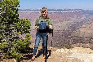 Becky Hoag films herself standing in front of the Grand Canyon