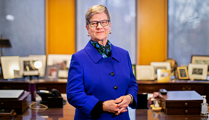 Kathleen Hall Jamieson wears a blue jacket and stands in her office