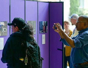 Trip leader Professor Ed Madison takes photos of the Big Easy Blues exhibit in Allen Hall while students look on