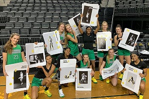 members of the 2020-21 UO women's basketball team pose with promotional posters designed by Allen Hall Advertising