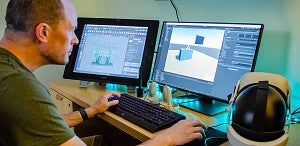 A person doing immersive design on two computer monitors 