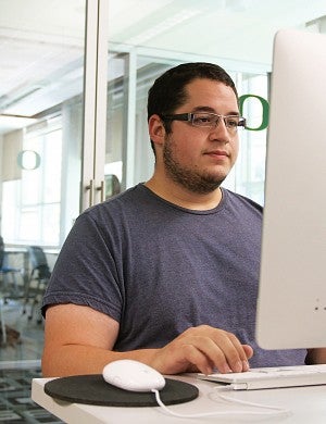 A male student working on a desktop computer A male student working on a desktop computer