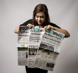 Destiny Alvarez holds a newspaper while posing for a photo during her Snowden internship.