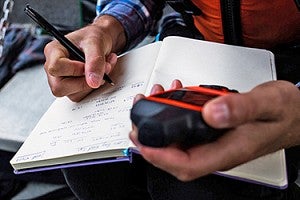 Recording results in notebook. Person writing in notebook.