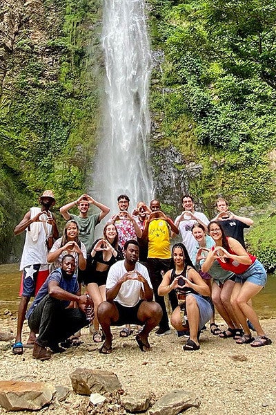 SOJC students throw their "O"s in front of a waterfall in Ghana