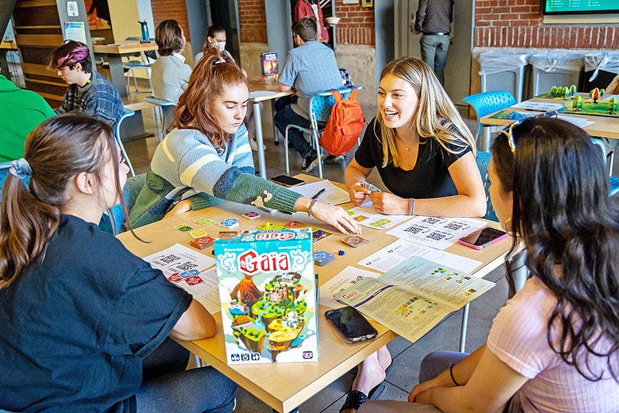 four students play the Gaia board game at SCR game night