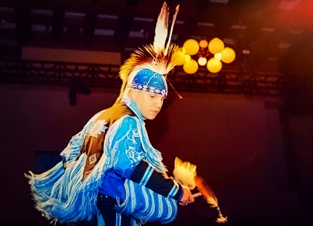 Tony Fuller performs a powwow dance in blue regalia