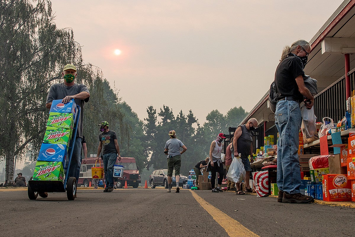 People stand near supplied after the fires forced people to evacuate from Thurston, Oregon. People stand near supplied after the fires forced people to evacuate from Thurston, Oregon.