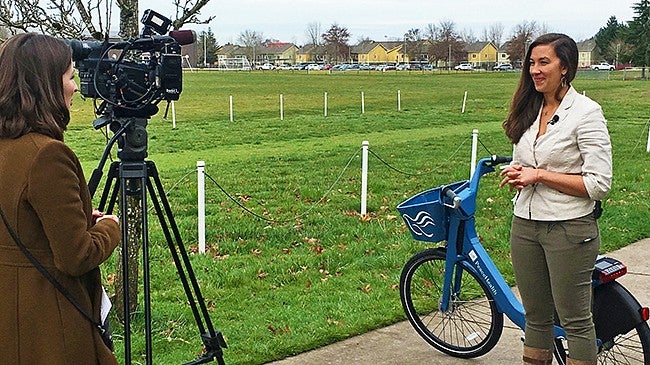A female student being interviewed on camera in front of a PeaceHealth Rides bike A female student being interviewed on camera in front of a PeaceHealth Rides bike
