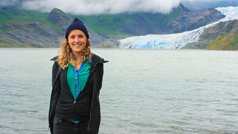 Maia Laperle poses in front of a glacier in Alaska