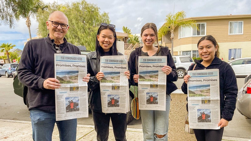 Craig Harris with three other staff members of the Coronado News; they are all holding copies of the front page of the paper