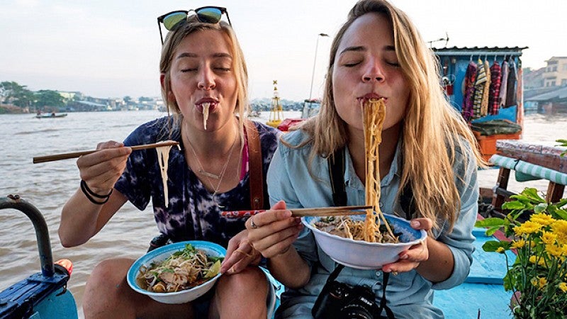 Two female students eating noodles