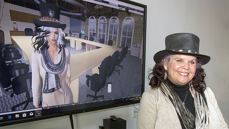SOJC Associate Professor Donna Davis standing with avatar. SOJC Associate Professor Donna Davis standing with avatar.